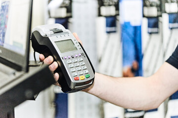 Salesman holds a contactless payment terminal in his hand