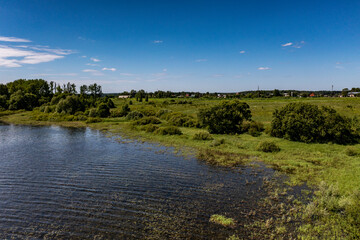 panoramic view from the drone to the village of a large lake and forest and fields and roads 