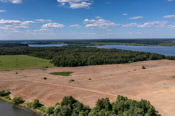 Fototapeta na wymiar panoramic view from the drone to the village of a large lake and forest and fields and roads 
