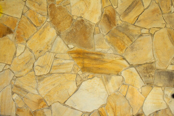 Wall clad with yellow flat stones bonded with cement