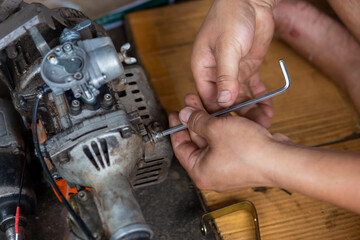 A small lawnmower Was disassembled for repair By a Thai mechanic The mower was adapted from a motorbike.