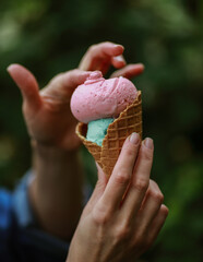 multicolored ice cream balls in a cup in hand