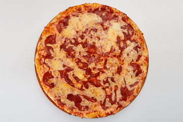 A whole round pizza with salami sausage and cheese on a white background.