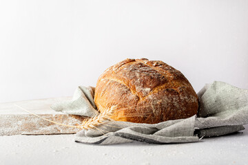 Round bread with a crispy brown crust on white background.