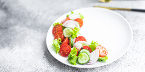 fresh salad vegetables tomato, cucumber, onion, lettuce organic dish on the table healthy food meal snack copy space food background rustic. top view keto or paleo diet veggie vegan or vegetarian