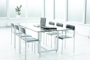 Laptop on glass table in spacious office space