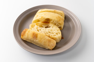 Freshly baked ciabatta bread is placed on a plate