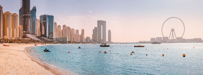 Panoramic views of the Persian Gulf beach and Bluewaters Island with the worlds famous largest Ferris wheel Dubai Eye and numerous skyscrapers with hotels and residences