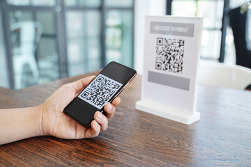 Online money, Close up hand holding smart phone for scanning Qr code for digital payment..