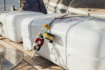 Life rafts in capsules are fixed on the teak deck of the yacht in close-up. Mechanism for fastening...