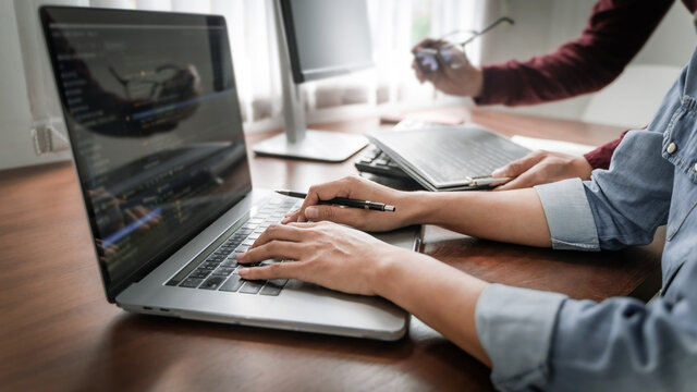 Programming developing software application. programmer writing program code with two monitors and working hacker on a new software