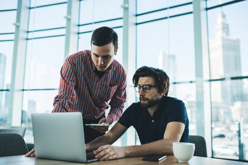 Serious multiethnic coworkers in modern workspace