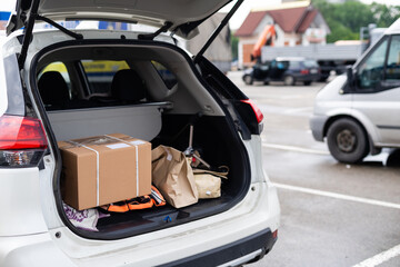 Blank paper bags in a car trunk - obrazy, fototapety, plakaty