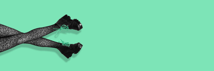 New gray female boots on long slender woman legs in gray tights isolated on mint background. Pop...