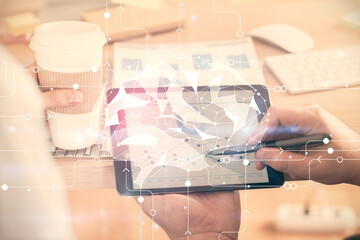 Double exposure of man's hand holding and using a digital device and brain hologram drawing. Data concept.
