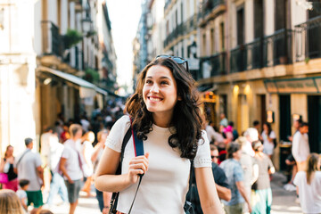 Obraz premium Happy young tourist woman visiting the lively Old Town of San Sebastian, Spain