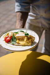Omelette in lavash with slices of pepper and spinach leafs on a plate
