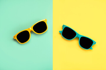Top view of green and yellow sunglasses on a green and yellow background