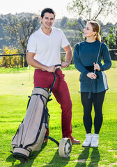 Obraz premium Glad cheerful man and woman golf partners ready to enjoy game at golf course