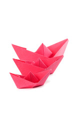 Red paper origami boats over white background.