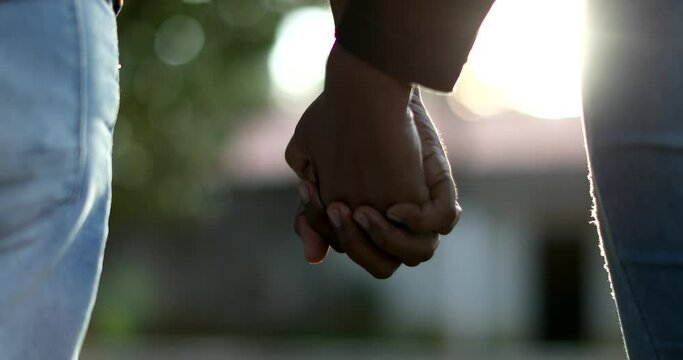 Black couple holding hands outside, two people hold hand