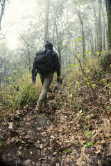 Male with a backpack hiking and climbing to the top of El Pinal volcanic mountain in Puebla, Mexico