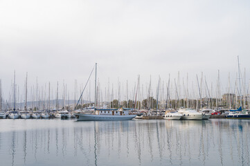 Fototapeta premium Yacht and boats parking in harbor. White sailing yachts at the pier. Sea yacht club. Aegean sea. Athens, Greece. Cloudy day.