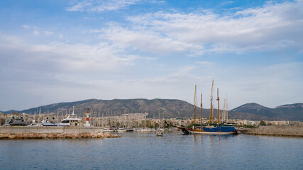 Wooden sailing ship. Yacht and boats parking in harbor. White yachts at the pier. Sea yacht club. Aegean sea. Athens, Greece. Cloudy day. Mountains on background.