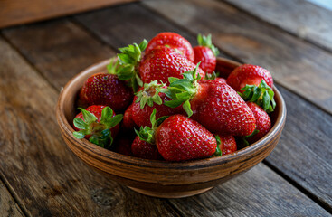 Strawberries in earthenware on an old wooden table. Cooking in the kitchen.
