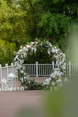 Wedding ceremony. Very beautiful and stylish roundwedding arch, decorated with various flowers, standing on the terrace.