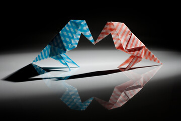 Bird origami made from colored paper isolated over black background