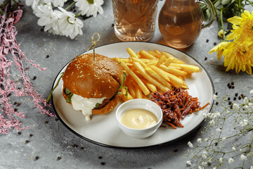 burger with fries and sauce on a white plate