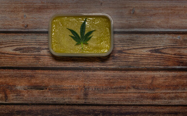 Marijuana butter on wooden table coffee gingerbread and green leafs
