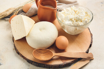 Different dairy products and chicken eggs on light background