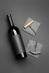 Bottle of wine and corkscrews on dark background