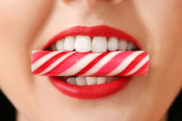 Fototapeta premium Beautiful young woman with sweet candy in mouth, closeup