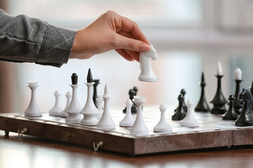 Young woman playing chess at home