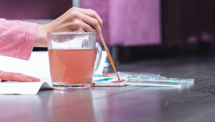Cute young girl draws a poster on the floor.