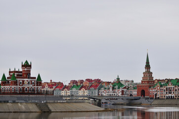 The new architecture of the city in the Brussels style of the Spasskaya Tower, the embankment of Bruges and the Theatre Bridge in cloudy weather. Russia Yoshkar Ola 01.05.2021. High quality photo