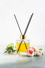 Reed diffuser with roses and lime on light background