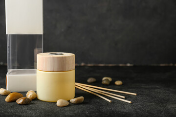 Reed diffuser with sea stones on dark background