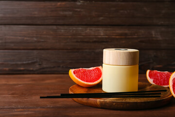 Fototapeta na wymiar Reed diffuser with grapefruit on wooden table