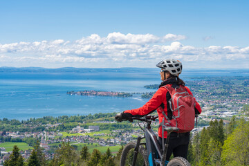 happy, active senior woman admiring a awesome view over Lake Constance with snow capped Swiss...