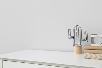 Stylish decor on shelf near light wall