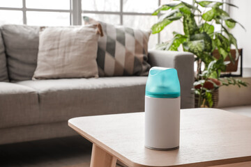 Fototapeta na wymiar Bottle of air freshener on table in living room