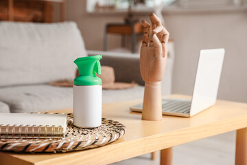 Bottle of air freshener and notebook on table in room