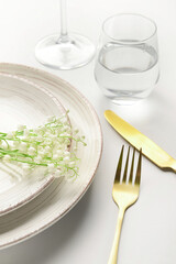Beautiful table setting with lily-of-the-valley flowers on light background