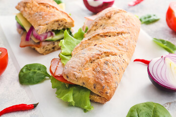 Tasty ciabatta sandwiches on light background