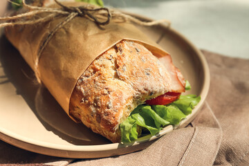 Plate with tasty ciabatta sandwich on table