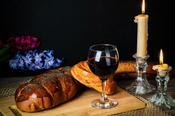 Shabbat Shalom. Challah bread, shabbat wine and candles on wooden table.